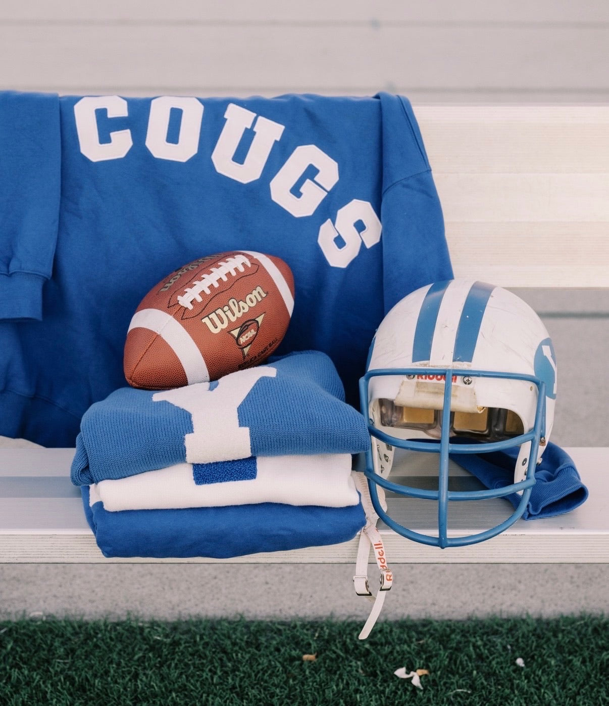 Sweatshirt, football, and helmet on bench