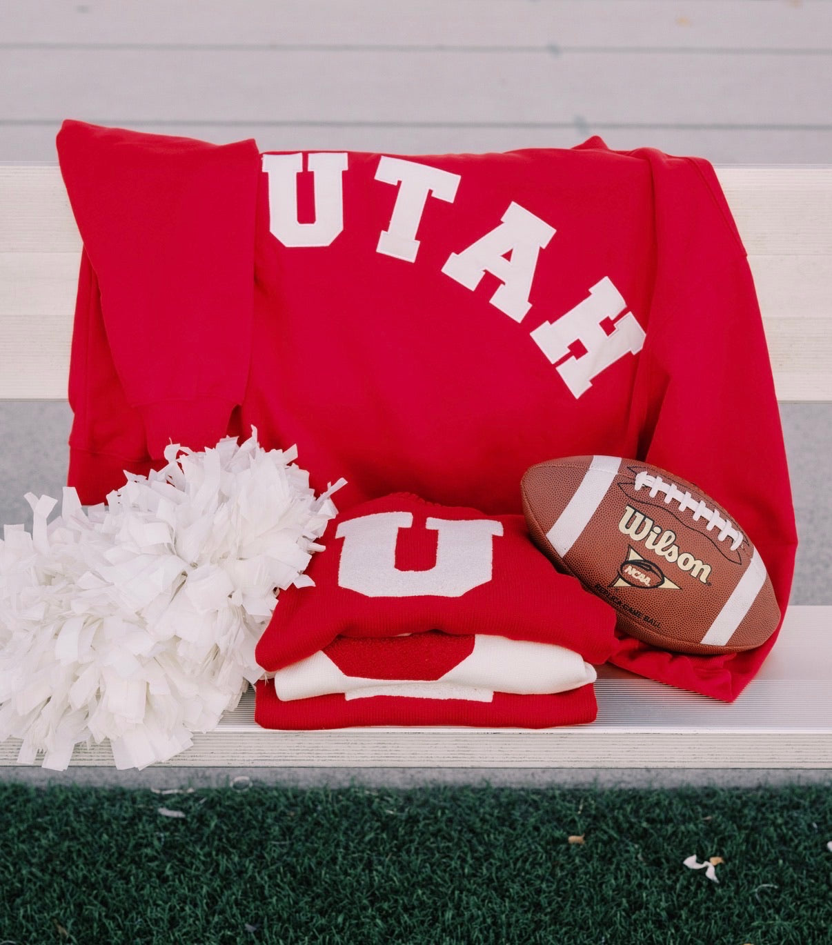 Sweatshirt, football, and helmet on bench
