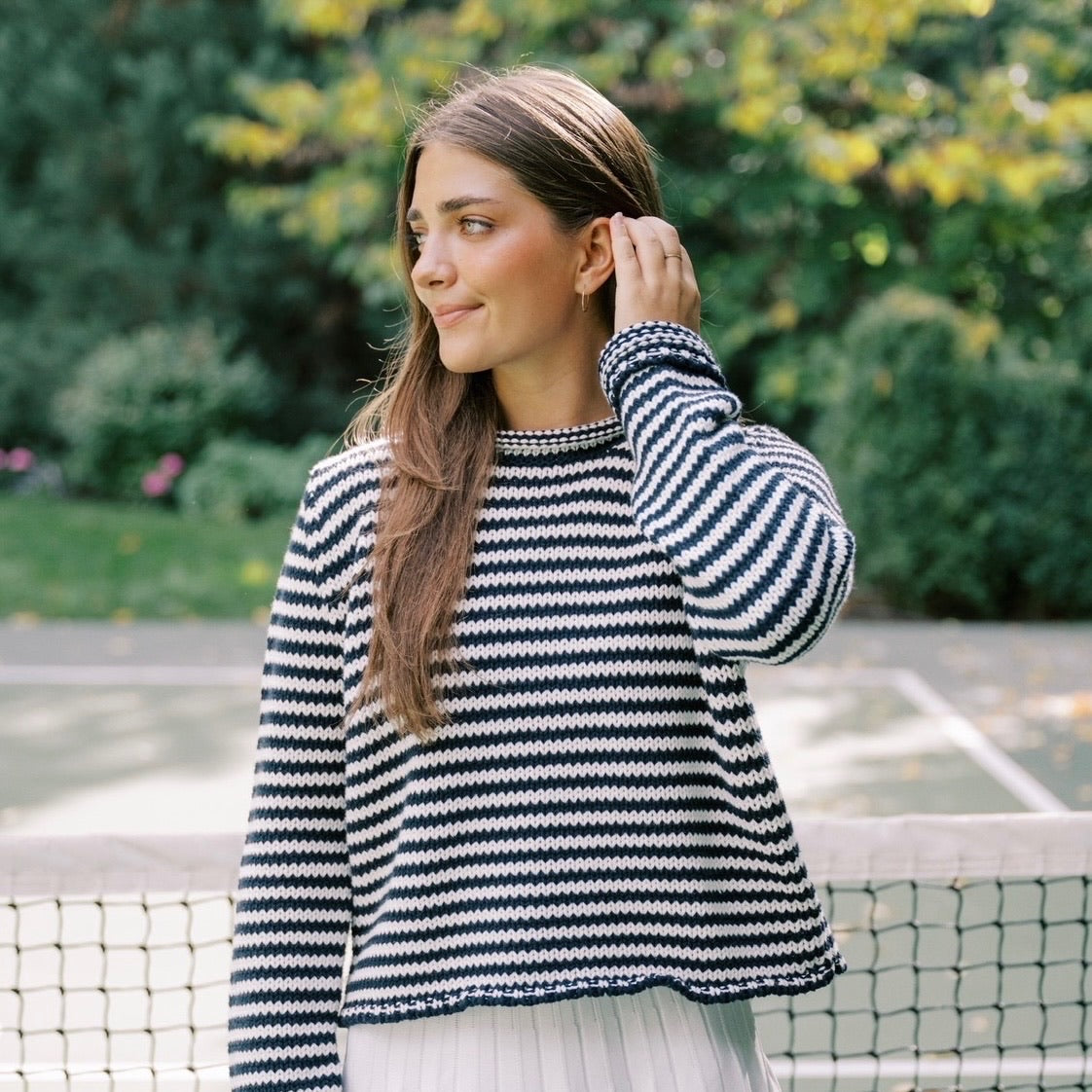 Woman wearing a sweater on a tennis court