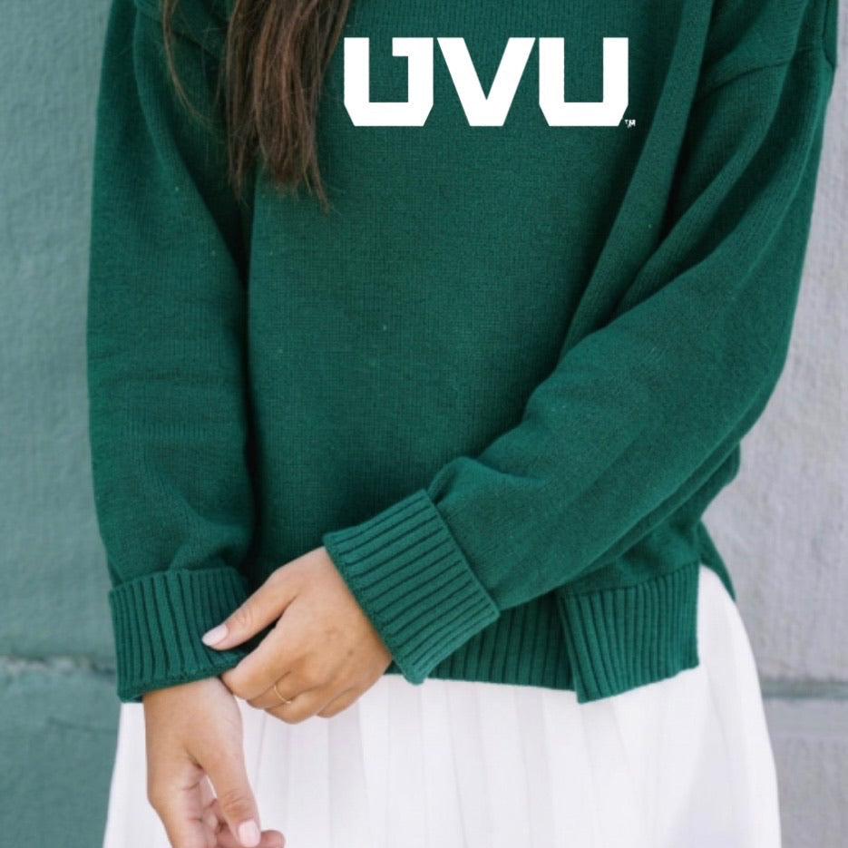 Green sweater with 'UVU' logo worn by a person, against a neutral background