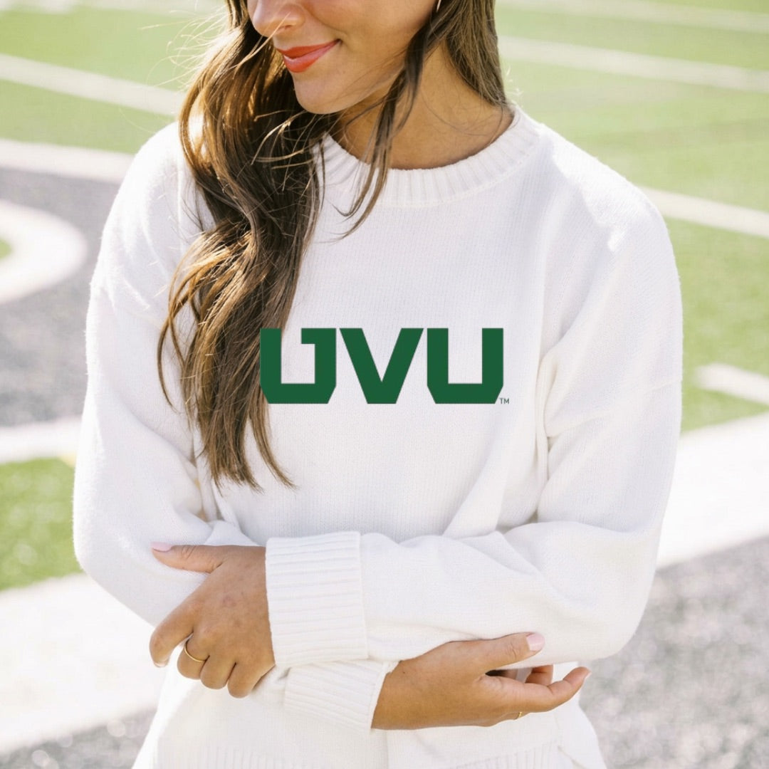 Person wearing a white sweater with 'UVU' printed on it, standing outdoors.
